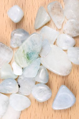 Aquamarine heap up jewel stones texture on light varnished wood background