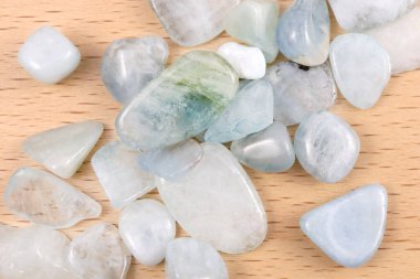 Aquamarine heap up jewel stones texture on light varnished wood background