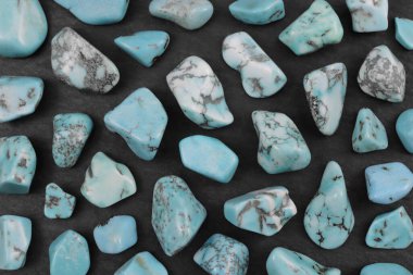 Türkuaz nadir mücevher taşları. Siyah taş arka planda.