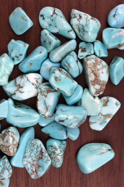 Turquoise heap up jewel stones texture on brown varnished wood background