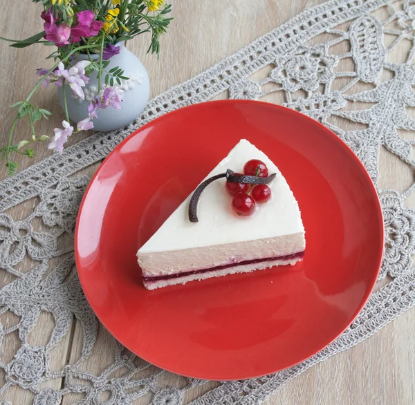 Cheesecake ile bej renkli arka plan üzerinde taze kırmızı kuş üzümü