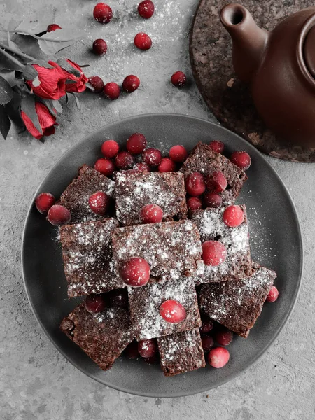 Brownie de chocolate sobre fondo gris con rosa roja y arándanos — Foto de Stock