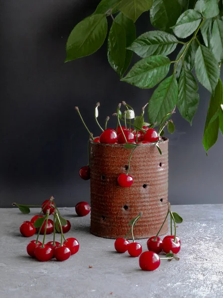 Cerezas maduras con hojas en una lata vieja — Foto de Stock