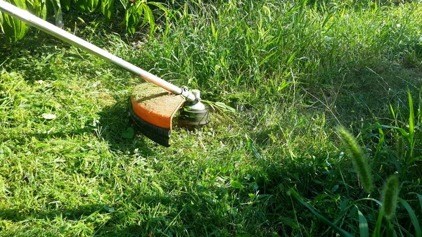 Bahçe aletleri yakın çekim. Bahçede çim biçme makinesiyle kesilmiş. Bahçede çalışmak için ot biçme makinesi.. 