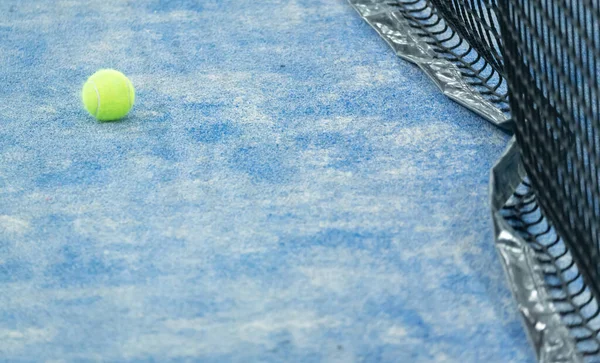 Tennis or paddle ball on the blue court and net