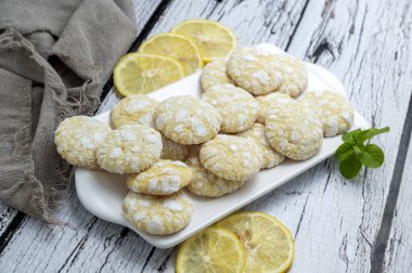 Çikolata, limon ve nane aromalı kurabiyeler ve beyaz tabakta şekerli kırmızı kadife kurabiyeler. Yemek stili.  