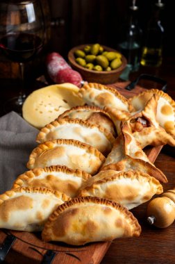 Et, jambon ve peynir, sebze, rokfor peyniri, domuz pastırması, yumurta, zeytin, vejetaryen ve vejetaryen ile dolu ev yapımı hamur ile pişirilmiş Creole börekleri.. 