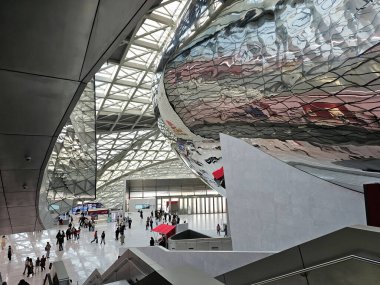 Shenzhen, Çin - 17 Ocak 2025: MOCAPE 'nin büyük salonu, ziyaretçiler büyük, yansıtıcı' Bulut 'heykeli ve geometrik tavan altında keşif yapıyorlar.