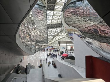 Shenzhen, Çin - 17 Ocak 2025: MOCAPE 'nin büyük salonunun yüksek açılı görüntüsü, ikonik' Bulut 'heykelini, geometrik tavanı ve aşağıdaki boşluğu keşfeden ziyaretçileri gösteriyor.