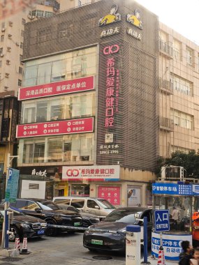 Shenzhen, Çin - 17 Ocak 2025: CKJ Stomatoloji binası, bir dişçi kliniği, işlek bir şehir caddesinde, arabaları ve çeşitli ticari tabelaları olan.