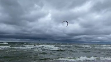 Bulutlu bir gri günde dalgalarda uçurtma. Yüksek kalite 4k görüntü
