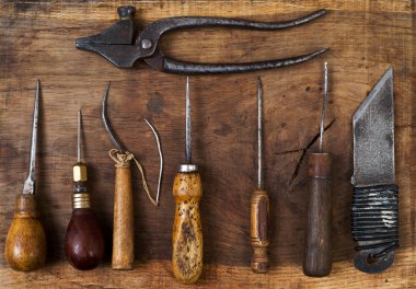 Deri el sanatları araçları ahşap arka plan üzerinde. Craftmans çalışma masası. Saklamak ve çalışma el yapımı araçlar parça. Üstten Görünüm.