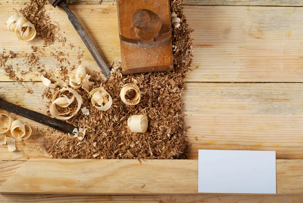 Visitekaartje op houten tafel voor timmerman tools met zaagsel. — Stockfoto