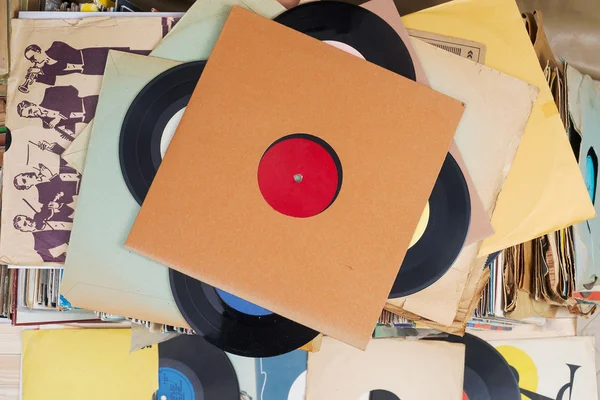 Vinyl record with copy space in front of a collection albums dummy titles, vintage process