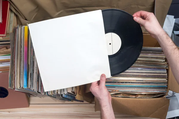 A navegar pela colecção de discos de vinil. Fundo musical. Espaço para cópia. Imagem retro estilo — Fotografia de Stock