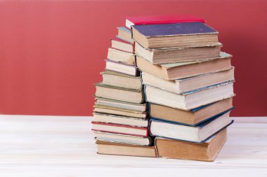 Ahşap masa üzerinde ciltli kitap yığını. Okula dönüş. Kopya alanı