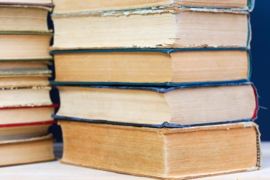 Ahşap masa üzerinde ciltli kitap yığını. Okula dönüş. Kopya alanı