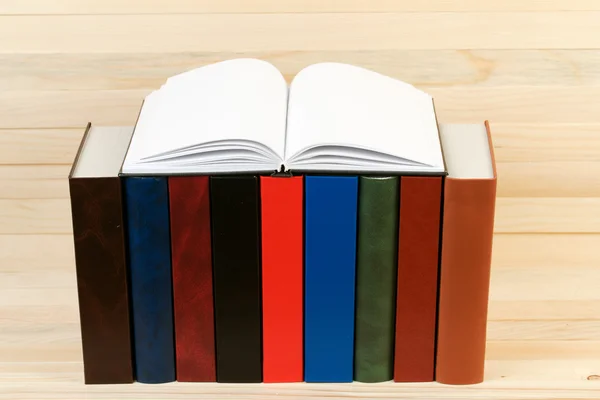 Öppen bok, stack av inbundna böcker på träbord. Tillbaka till skolan. Kopiera utrymme. — Stockfoto