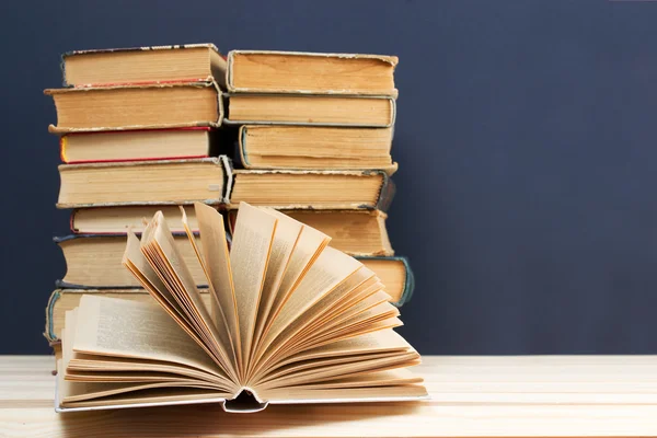 Libro abierto, pila de libros de tapa dura sobre mesa de madera. De vuelta a la escuela. Copiar espacio —  Fotos de Stock