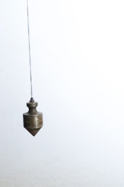 Metal plummet hanged on a rope. clipart