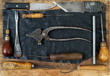 Deri el sanatları araçları ahşap arka plan üzerinde. Craftmans çalışma masası.