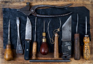 Deri el sanatları araçları ahşap arka plan üzerinde. Craftmans çalışma masası.