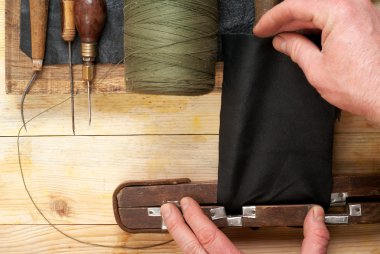 Deri el sanatları araçları ahşap arka plan üzerinde. Craftmans işçiliği DIY araçları kullanarak deri ile çalışma. Çalışma tablosu gizle ve çalışma el yapımı araçları parçası. Üstten Görünüm