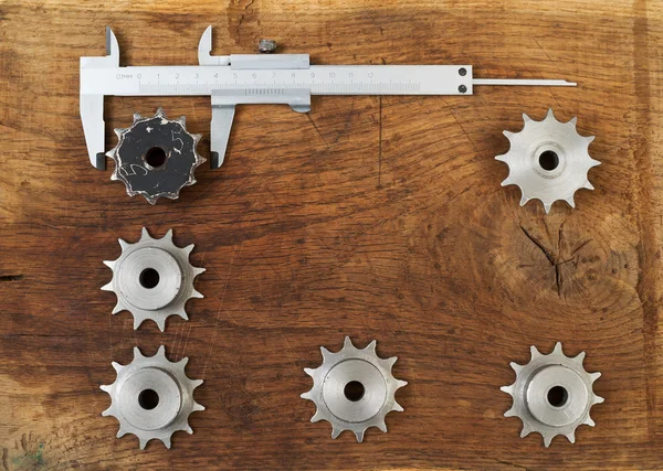 Herramientas de ingeniería engranajes y pinza en mesa de madera. Concepto de éxito . — Foto de Stock