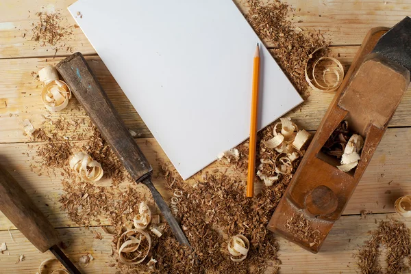 Weißes Blech auf Holztisch für Zimmermannswerkzeuge mit Sägemehl. — Stockfoto