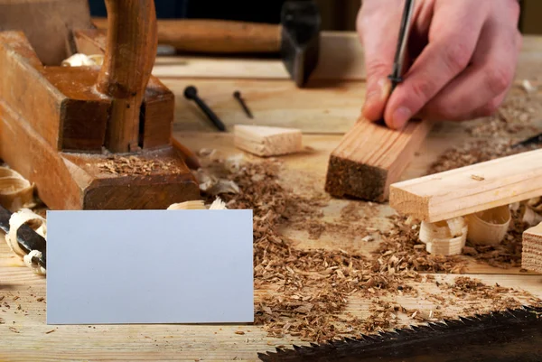 Business card on wooden table for carpenter tools with sawdust. — Stock Photo, Image