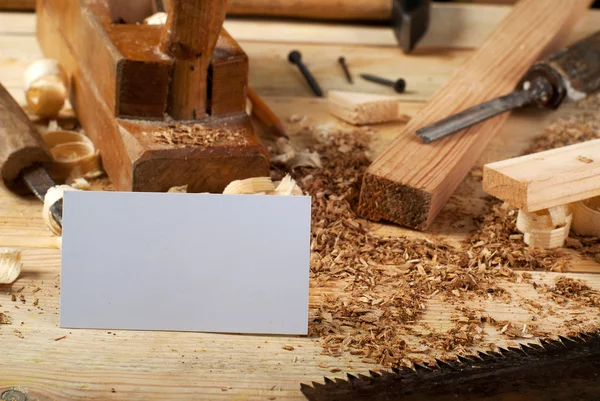 Tarjeta de visita sobre mesa de madera para herramientas de carpintería con serrín . — Foto de Stock