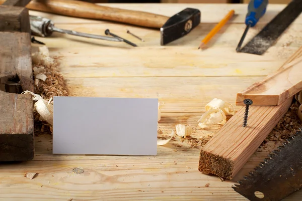 Tarjeta de visita sobre mesa de madera para herramientas de carpintería con serrín . — Foto de Stock