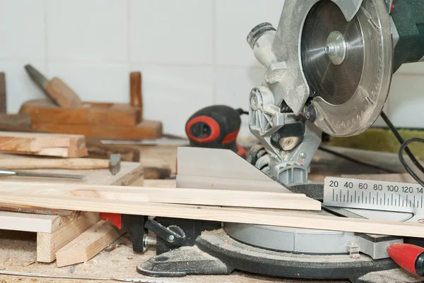 Herramientas de carpintería sobre mesa de madera con serrín. Sierra circular. Cortar una tabla de madera — Foto de Stock