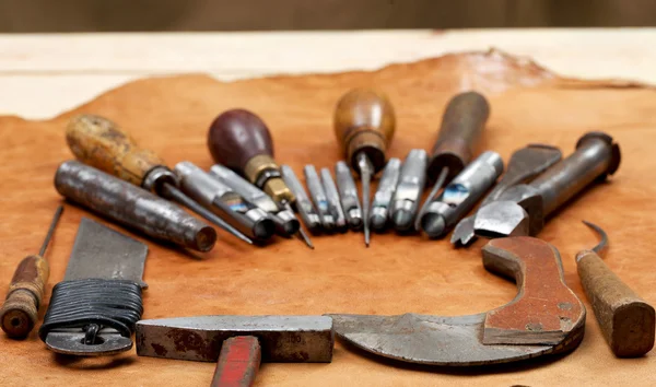 Lederen craft tools op de achtergrond. Bureau van de ambachtsman. — Stockfoto