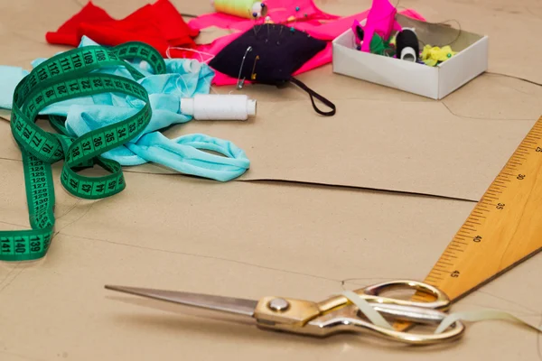 Sewing textile or cloth. Work table of a tailor. Textile tools. Scissors reel of thread,  measuring tapes and natural fabric. Copy space