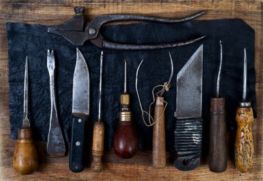 Deri el sanatları araçları ahşap arka plan üzerinde. Craftmans çalışma masası.