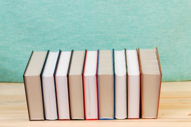 Ahşap masa üzerinde ciltli kitap yığını. Okula dönüş. Kopya alanı