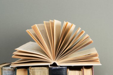 Açık kitap, ahşap masa üzerinde ciltli kitap yığını. Okula dönüş. Kopya alanı