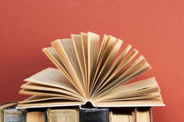 Açık kitap, ahşap masa üzerinde ciltli kitap yığını. Okula dönüş. Kopya alanı