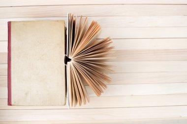 Açık kitap, ahşap masa üzerinde ciltli kitap yığını. Okula dönüş. Uzay kopyalayın. Üstten Görünüm