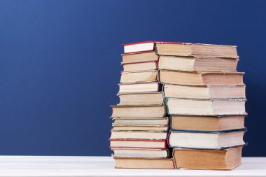 Ahşap masa üzerinde ciltli kitap yığını. Okula dönüş. Kopya alanı