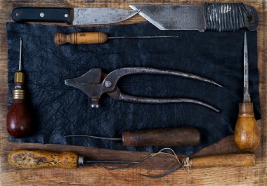 Deri el sanatları araçları ahşap arka plan üzerinde. Craftmans çalışma masası.