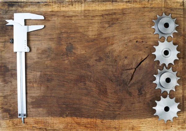 Herramientas de ingeniería engranajes y pinza en mesa de madera. Concepto de éxito . — Foto de Stock