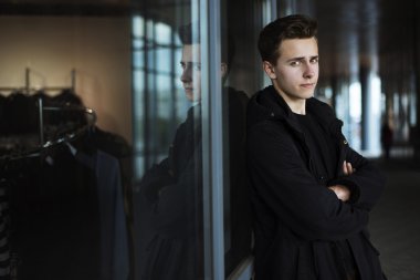 Siyah palto ayakta eller c ile alışveriş yakınındaki yakışıklı delikanlı