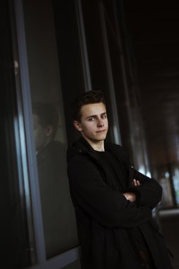 Siyah palto ayakta eller c ile alışveriş yakınındaki yakışıklı delikanlı