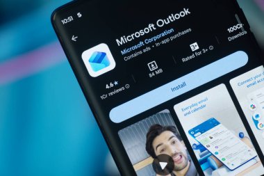 Dhaka, Bangladeş 26 Aralık 2025: Mikrosoft görünüm logosu bir akıllı telefon ekranında sergilenmektedir, arkaplanda bir bilgisayar ekranında bir stok grafik web sayfası görünür.