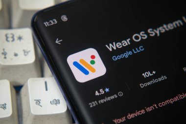 Dhaka, Bangladeş 07 Aralık 2025: Kulaklıkların yanında Google uygulama yükleme ekranı tarafından gösterilen akıllı telefon
