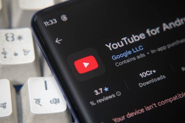 Dhaka, Bangladeş 07 Aralık 2025: Android TV uygulama bilgileri için yakındaki kulaklıklar ile YouTube 'u gösteren bir akıllı telefon ekranı