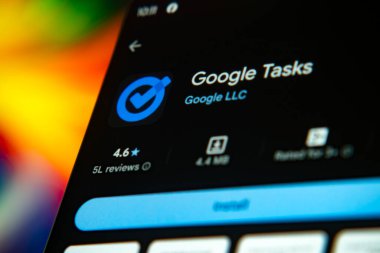 Dhaka, Bangladeş 26 Aralık 2025: Google Görevleri uygulamasını siyah kulaklıklarla mavi bir arkaplan karşısında gösteren akıllı telefon