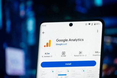 Dhaka, Bangladeş 26 Aralık 2025: Google Analitik logosunu yanan bir klavyenin önünde gösteren bir akıllı telefon ekranı